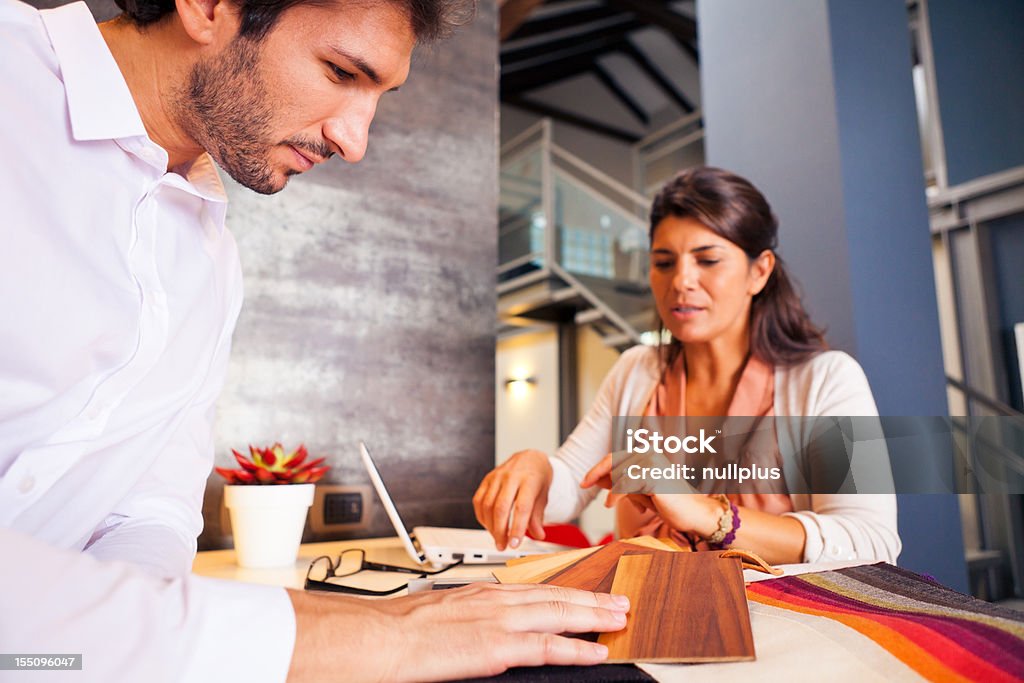 couple talking to their interior designer a couple is talking to their interior designer about possibilities to furnish their new home. Interior Designer Stock Photo