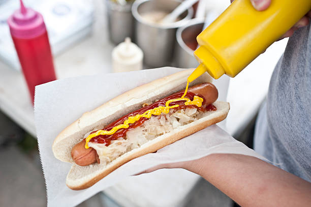 Street hot dog woman holding a hotdog out in New York City hot dog stand stock pictures, royalty-free photos & images