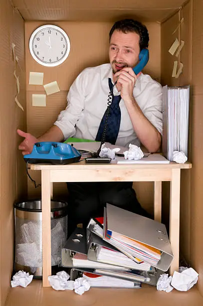 businessman working in an office in a box - concept small office
