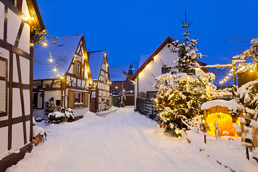 An old street with half-timbered houses and christmas lights at night.
