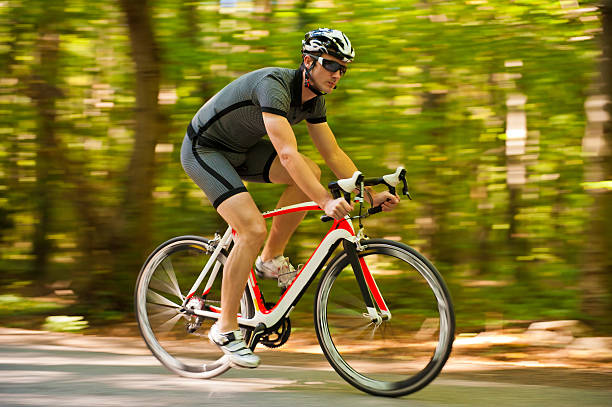 ciclista de estrada na floresta - racing bicycle cyclist sports race panning imagens e fotografias de stock