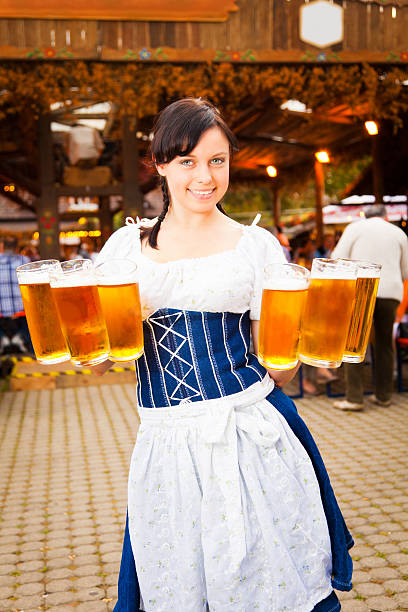 jeune femme servant de la bière allemande - serving drink beer garden beer glass photos et images de collection