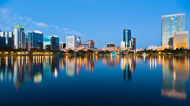 orlando skyline bei sonnenuntergang gesehen von lake eola - apartment skyscraper florida architecture stock-fotos und bilder