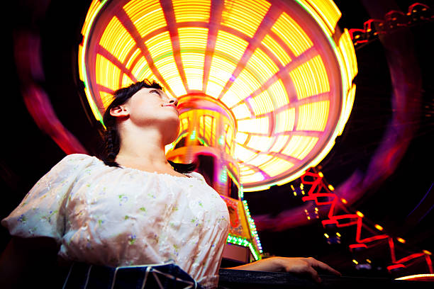young woman standing next to brightly colored carousel