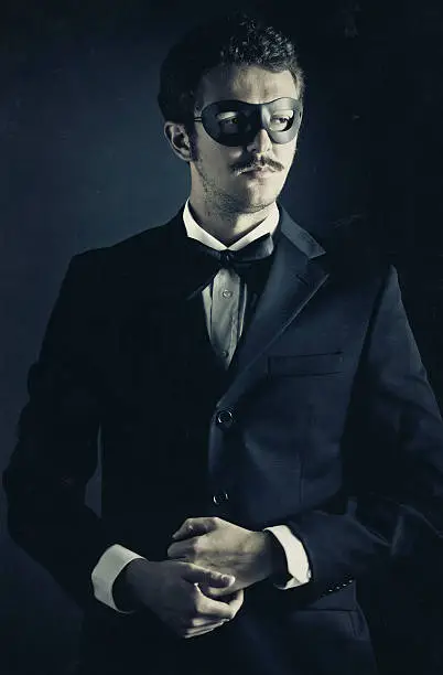 vintage style elegant superhero wearing a suit with bow-tie and a black mask.