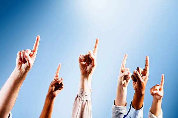 istock Six hands point upwards towards heavenly ray of light 155096799