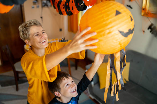 istock A woman is hanging a pumpkin halloween decoration 1550968770