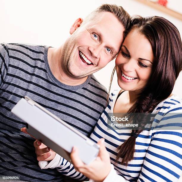 Casal Sentado Pela Cama Com Um Tablet Pc - Fotografias de stock e mais imagens de 30-34 Anos - 30-34 Anos, 30-39 Anos, 35-39 Anos