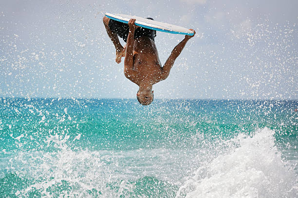 surfer, die einen backflip - surfing surf wave extreme sports stock-fotos und bilder