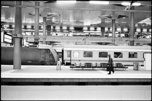 A man walks on a empty platform at a train station. 35mm film scan.
