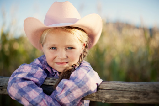 A young American cowbgirl smiles.
