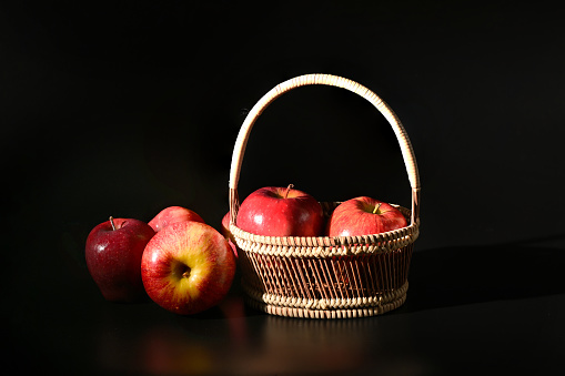 Close-up of fresh red apples in the basket on dark background