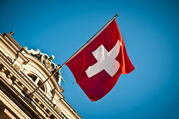 bandera suiza saludar con la mano en el histórico edificio - switzerland fotografías e imágenes de stock