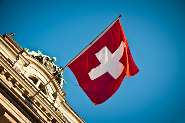 agitant le drapeau suisse bâtiment historique - culture suisse photos et images de collection