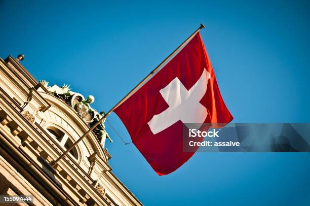 Foto de Bandeira Suíça Acenando No Edifício Histórico e mais fotos de stock de Bandeira Suíça - Bandeira Suíça, Suíça, Cultura Suíça