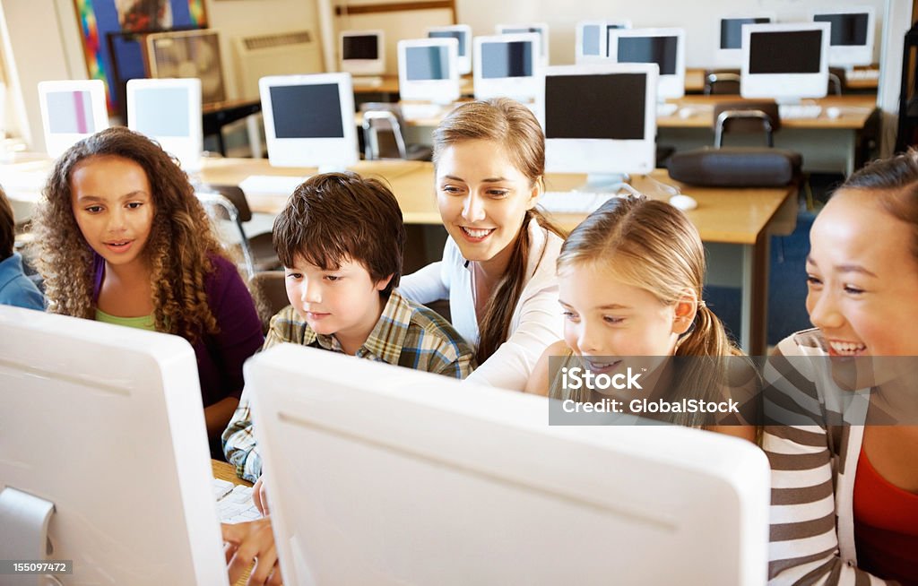 Students at computer class Group of multi racial students at computer class with their teacher 20-29 Years Stock Photo