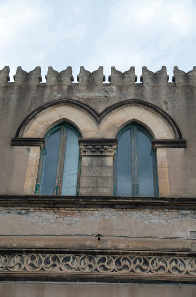 istock Old facade with arched double window and battlements in Italy 1550978973