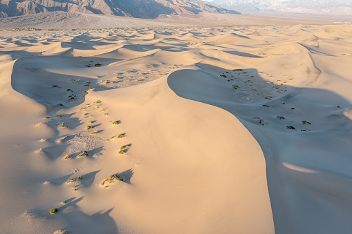 Scenic view on natural ripple sand pattern during sunrise at. Morning desert.\nTop down view of sand dunes, aerial.\nGlobal warming