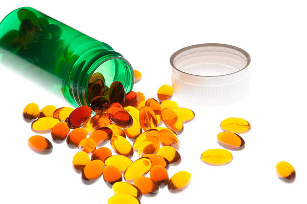 derramado cor de âmbar vitaminas - capsule pill lecithin fish oil - fotografias e filmes do acervo