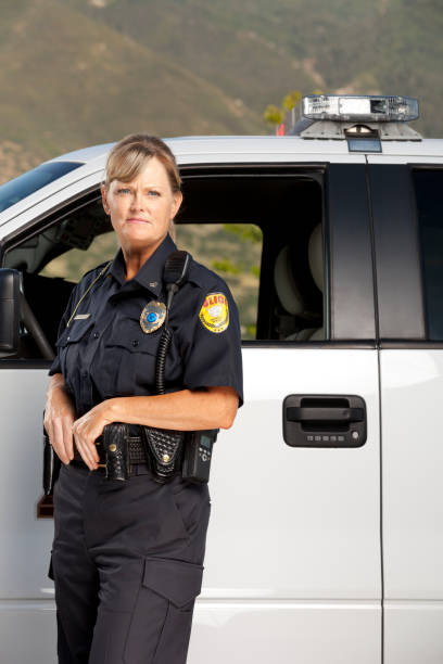 Police Woman on Patrol Police Woman on patrol. This stock image has a vertical composition. Arm Badge Create by me, Gold Chest Emblem Custom Ordered Generic female police officer stock pictures, royalty-free photos & images
