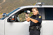 Female Police Officer checking vehicle speed with radar gun