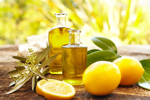 Massage oil bottles at spa outdoors with lemons Massage oil bottles at spa outdoors with lemons and green leaves  aromatherapy oil photos stock pictures, royalty-free photos & images