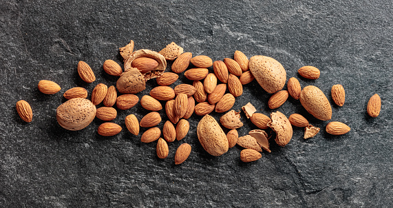 Almonds on a black stone background. Top view.