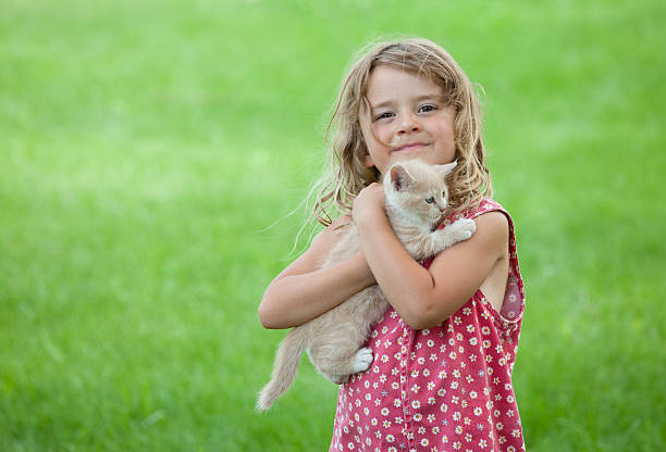 ragazzo carino caucasico ragazza con gattino - two girls only cheerful front view horizontal foto e immagini stock