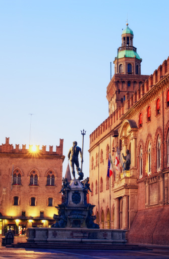 Neptune fountain, Piazza Maggiore and twonhall building with statue of San Petronio in Bologna Italia at dawn.