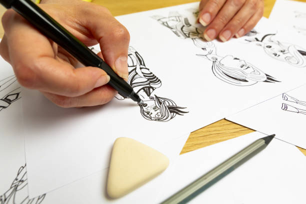 istock The artist draws on paper characters for computer games or comics. 1550985136