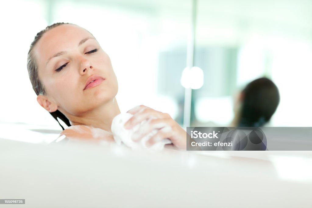 Attraente giovane donna lavaggio In vasca da bagno - Foto stock royalty-free di 25-29 anni