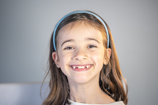 Little happy kid girl at dentist office smiling showing overbite teeth, child during orthodontist visit and oral cavity check-up, children tooth care and hygiene.