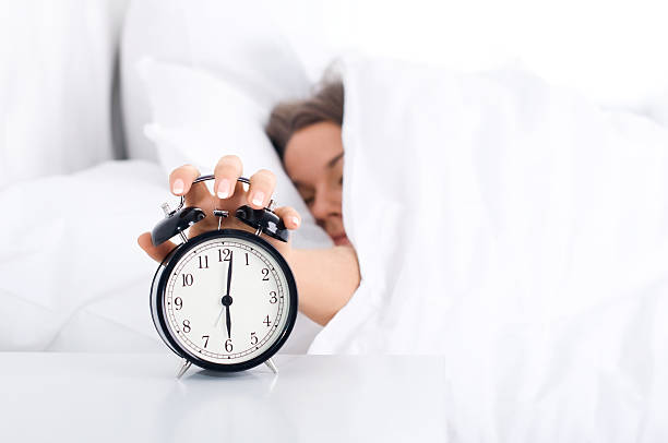 istock Woman turning off alarm clock from under the covers 155099141