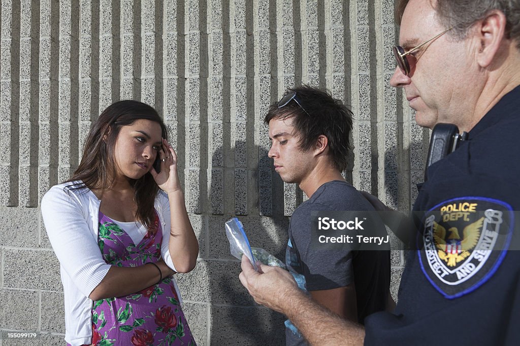 Arrested A young woman cries as her boyfriend is arrested for having a bag of marijuana. Police Force Stock Photo