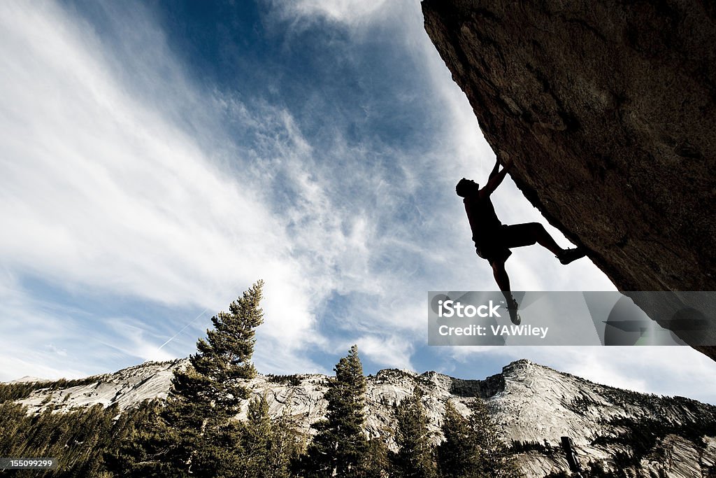 action A man climbing a cliff in the wilderness  Activity Stock Photo