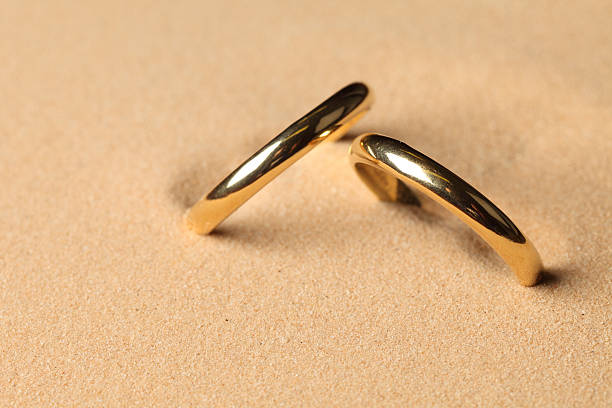 Wedding rings in the sand Wedding rings in the sand on the beach ring tilt stock pictures, royalty-free photos & images