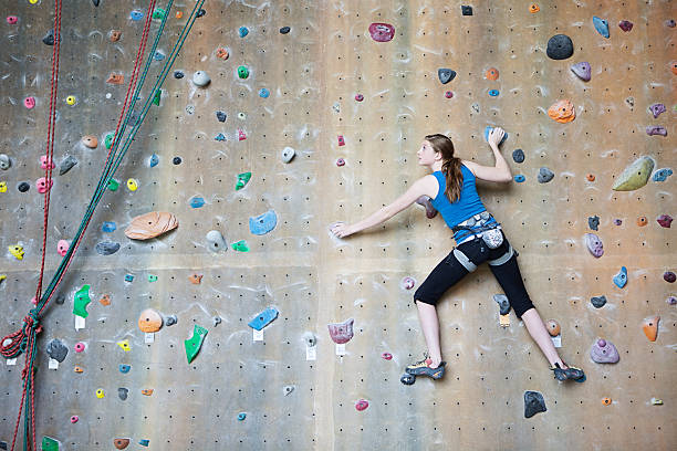Young rock climber climbing on wall
