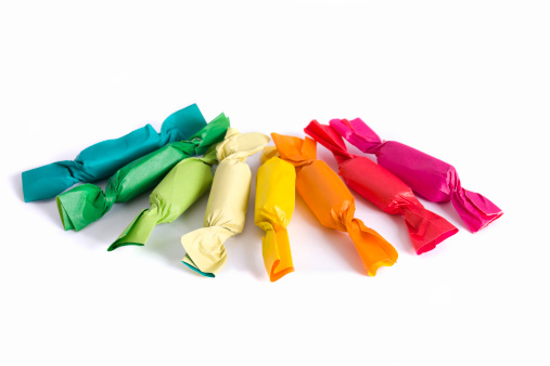 Assorted colorful candies in paper wraps on white background