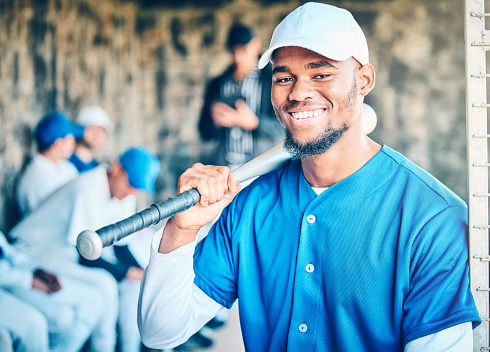 Baseball team, black man portrait and smile of a player in sports dugout ready for fitness. Exercise, sport training and happiness of an athlete at a stadium for workout, game and competition