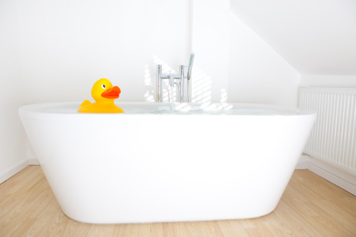 Yellow rubber duck in bubble bath.