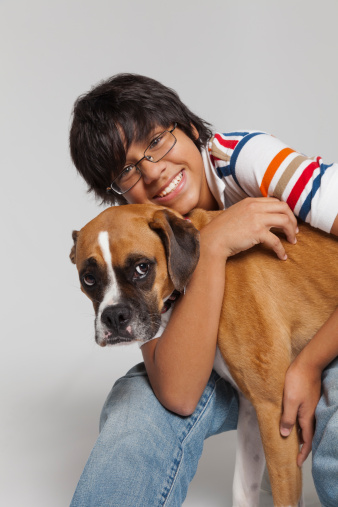 Boy hugging boxer dog, smiling, portrait