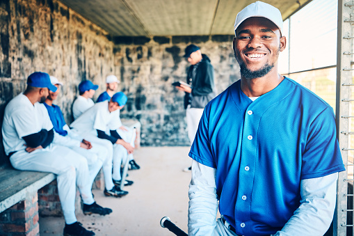 Baseball player, dugout and happy portrait of a black man with sports team and smile in stadium. Exercise, fitness athlete and training motivation of a softball group at game feeling happiness