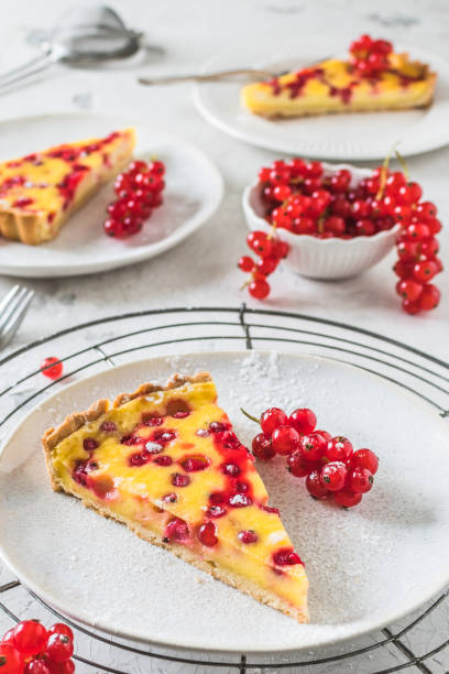 istock Piece of homemade red currant pie on white background, decorated with fresh red currants, vertical 1551034486