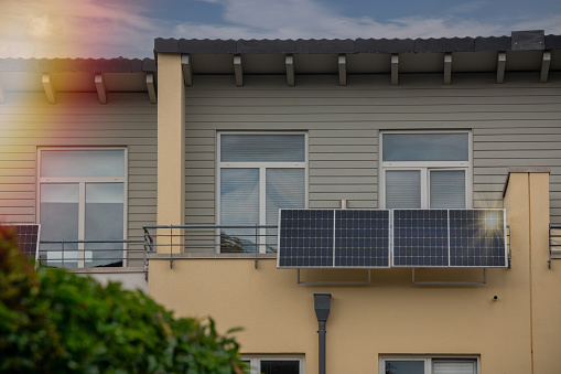 Solar power plant on a balcony with sunlight reflection and special lens flare light effect. Balcony solar power station eco-friendly to use renewable energy.