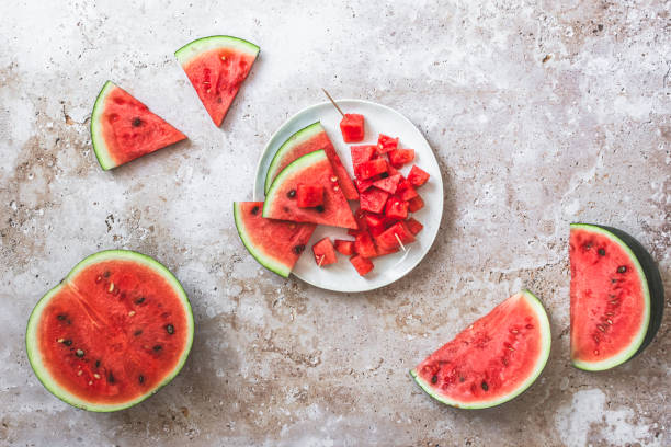 istock Sliced and chunky fresh watermelon on beige structured background 1551043772