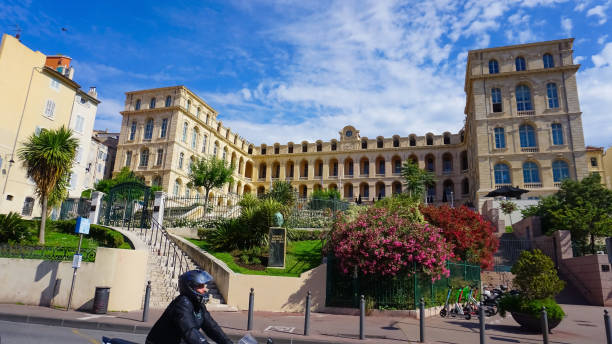 A statue of Honore Daumier artist is seen in front of Intercontinental Marseille The Hotel Dieu Marseille, France - May 29, 2023: A statue of Honore Daumier artist is seen in front of Intercontinental Marseille The Hotel Dieu in Panier district of Marseille, France marseille panier stock pictures, royalty-free photos & images