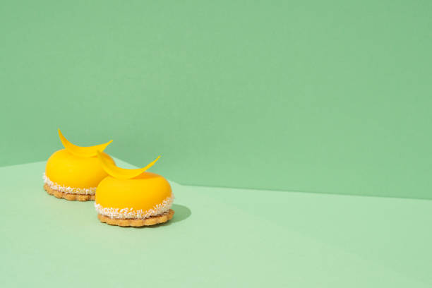 istock Yellow cupcakes with whipped icing on top and a green background 1551067668