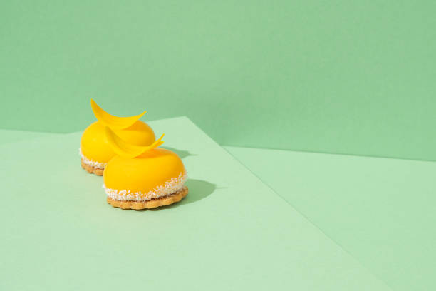 istock Yellow cupcakes with whipped icing on top and a green background 1551067674