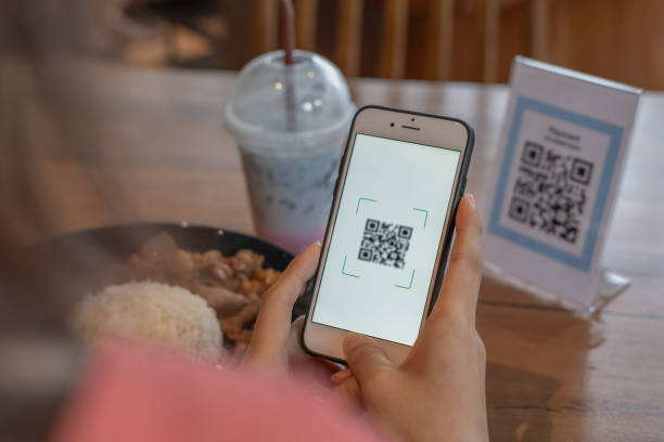 istock Woman use smartphone to scan QR code to pay in cafe restaurant with a digital payment without cash. Choose menu and order accumulate discount. E wallet, technology, pay online, credit card, bank app. 1551081090