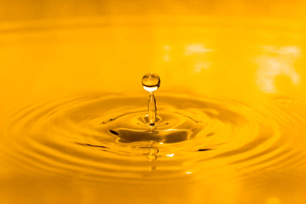 istock yellow drop oil , Liquid gold oil drop ripple background 1551093432